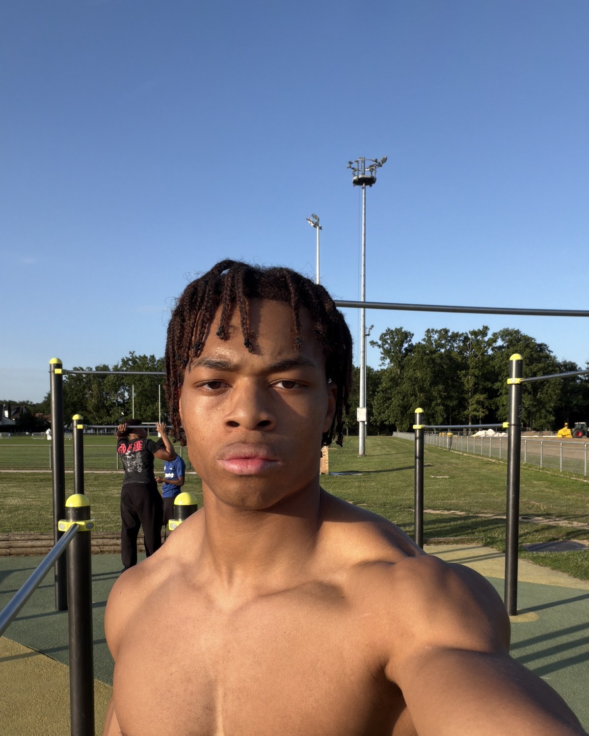 Kevin Nguena at an outdoor calisthenics park, pull-up bars behind him