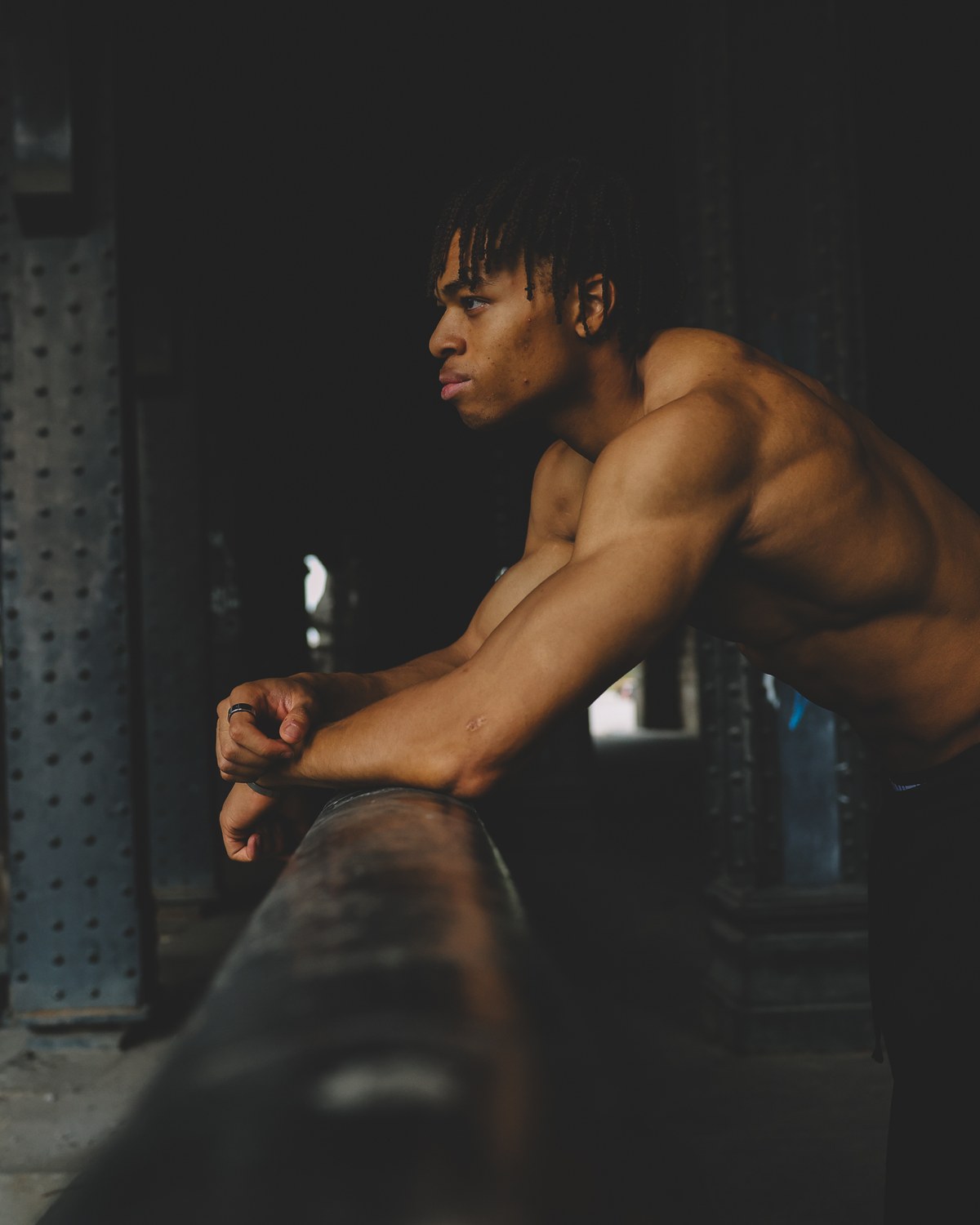 Kevin Nguena leaning on a rail under a steel bridge